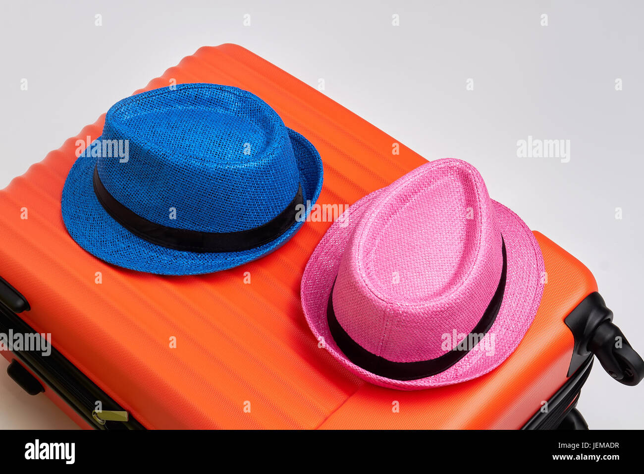 Colorful hats on modern suitcase. Close up of luggage with summer hats. Time for travelling. Stock Photo