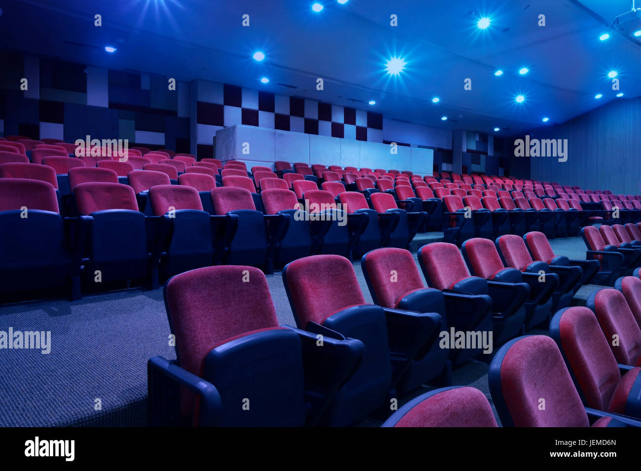 Bright blue light with black armchairs in movie theater Stock Photo