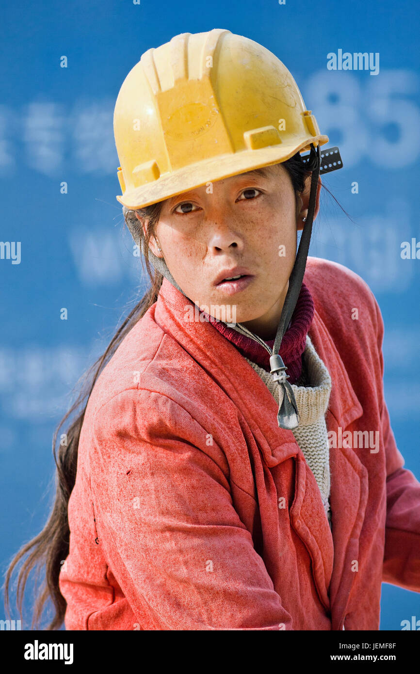 Female construction worker. Among millions of Chinese migrant workers, one-third are women, they get only paid 33 percent of what men  get paid. Stock Photo