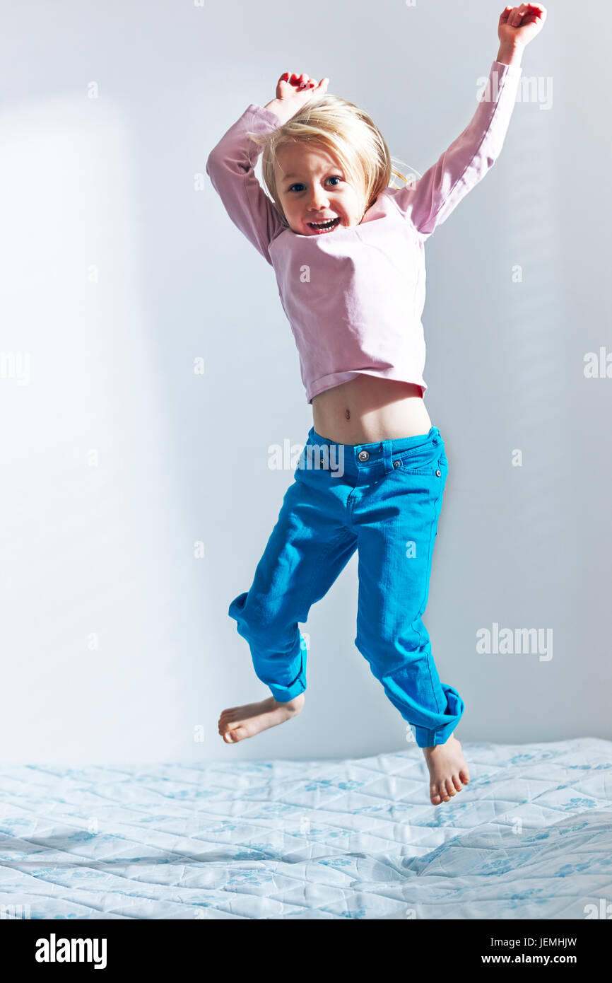 Girl jumping on bed Stock Photo Alamy