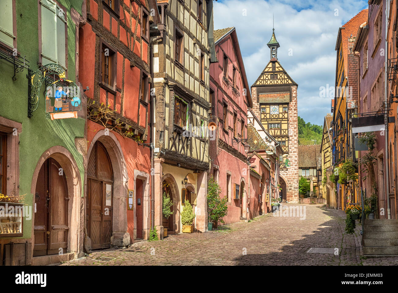 Central street of Riquewihr village with colorful traditional half-timbered french houses and Dolder Tower, Alsace, France Stock Photo