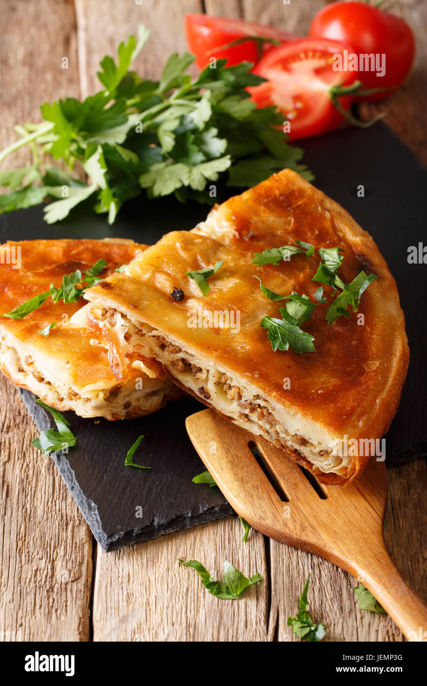 Homemade sliced burek stuffed with meat close-up on a table. Vertical Stock Photo