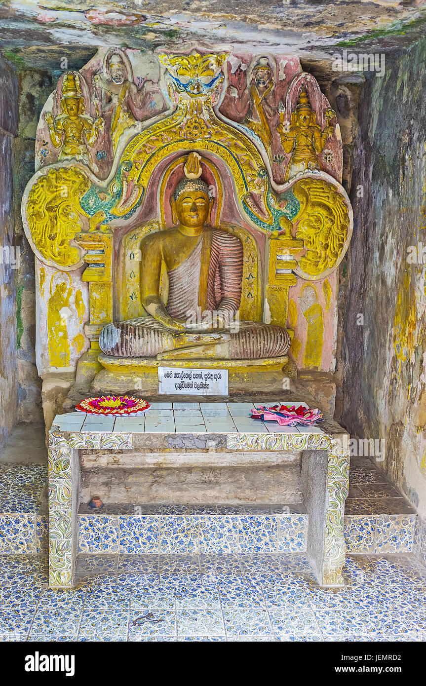 PILIMATHALAWA, SRI LANKA - NOVEMBER 11, 2016: The altar with the carved statue of Lord Buddha, surrounded by reliefs in Vijayantha Prasada shrine of G Stock Photo