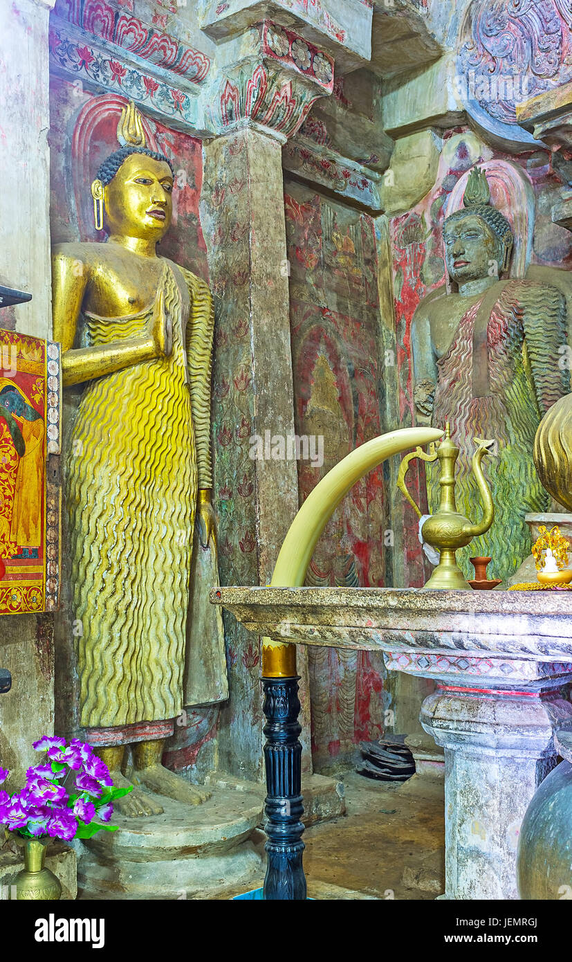 PILIMATHALAWA, SRI LANKA - NOVEMBER 11, 2016: Interior of Gadaladeniya Vihara Buddhist Temple with statues of Lord Buddha, stone altar and frescoes on Stock Photo
