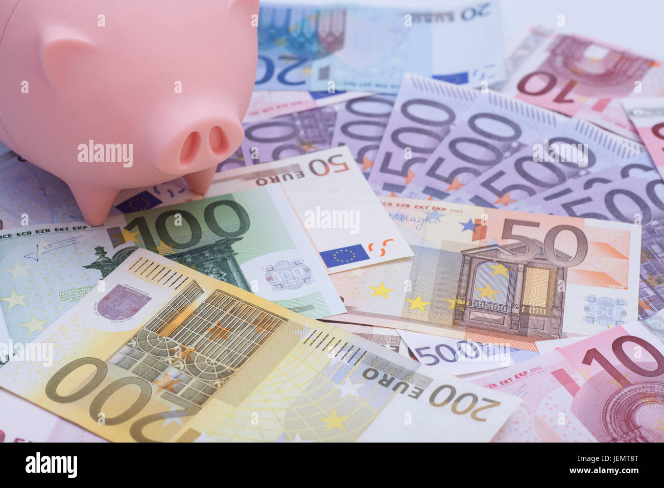 Pink piggy bank surrounded by euro banknotes Stock Photo
