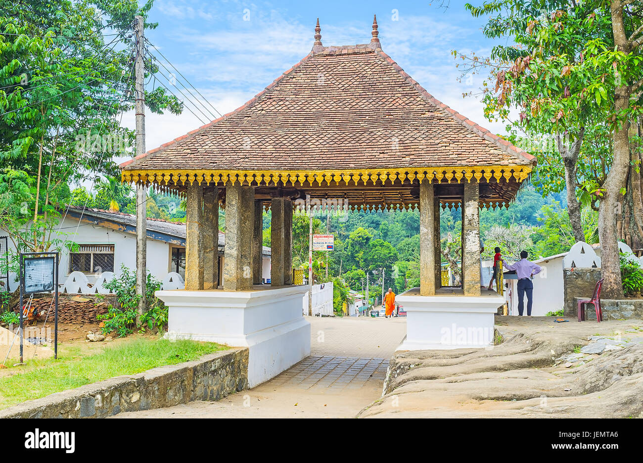 UDUNUWARA, SRI LANKA - NOVEMBER 29, 2016: The gate of Lankathilaka Vihara with old stone pillars and carved wooden roof, covered with tile, on Novembe Stock Photo