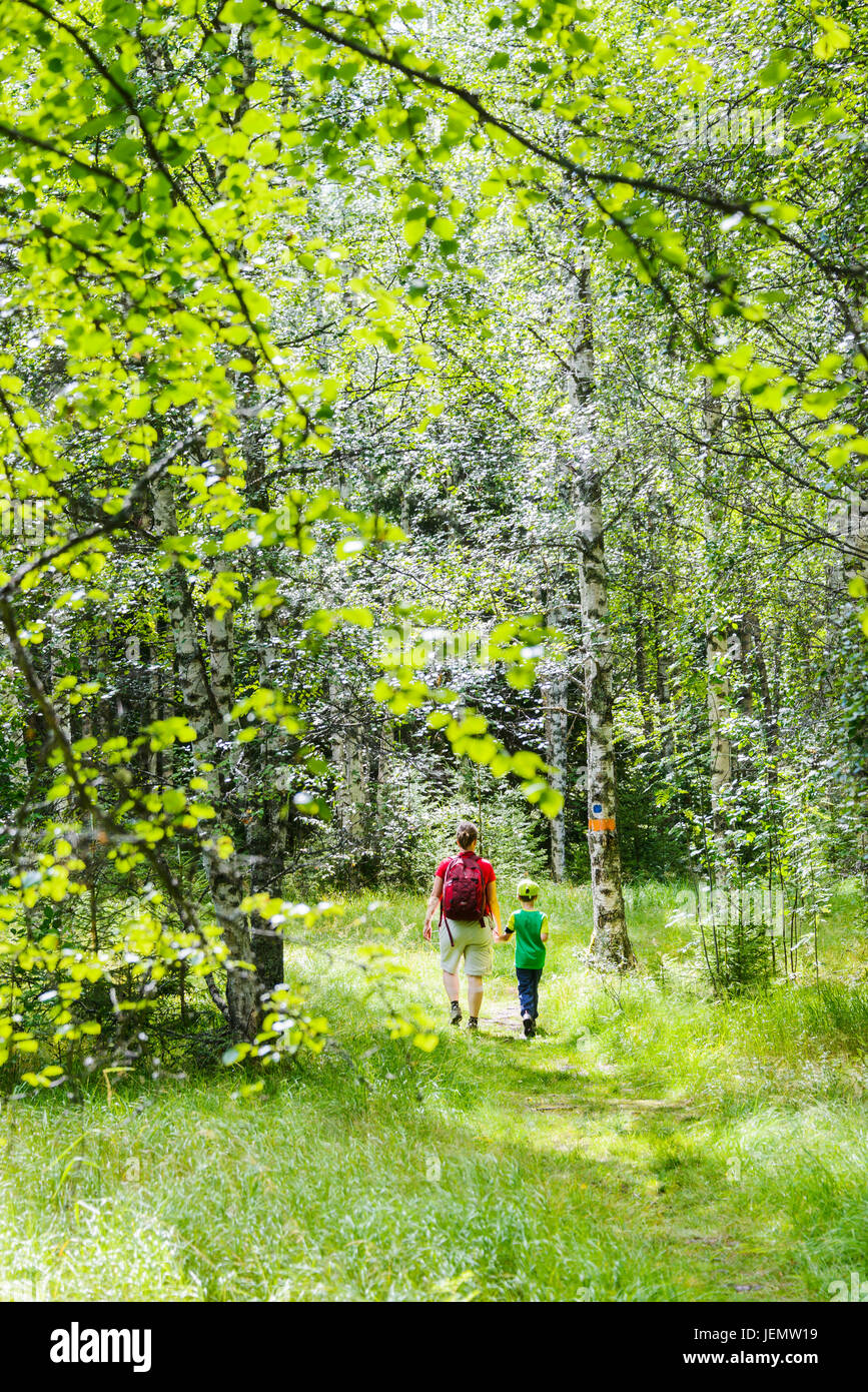 Mother with son walking through forest Stock Photo - Alamy