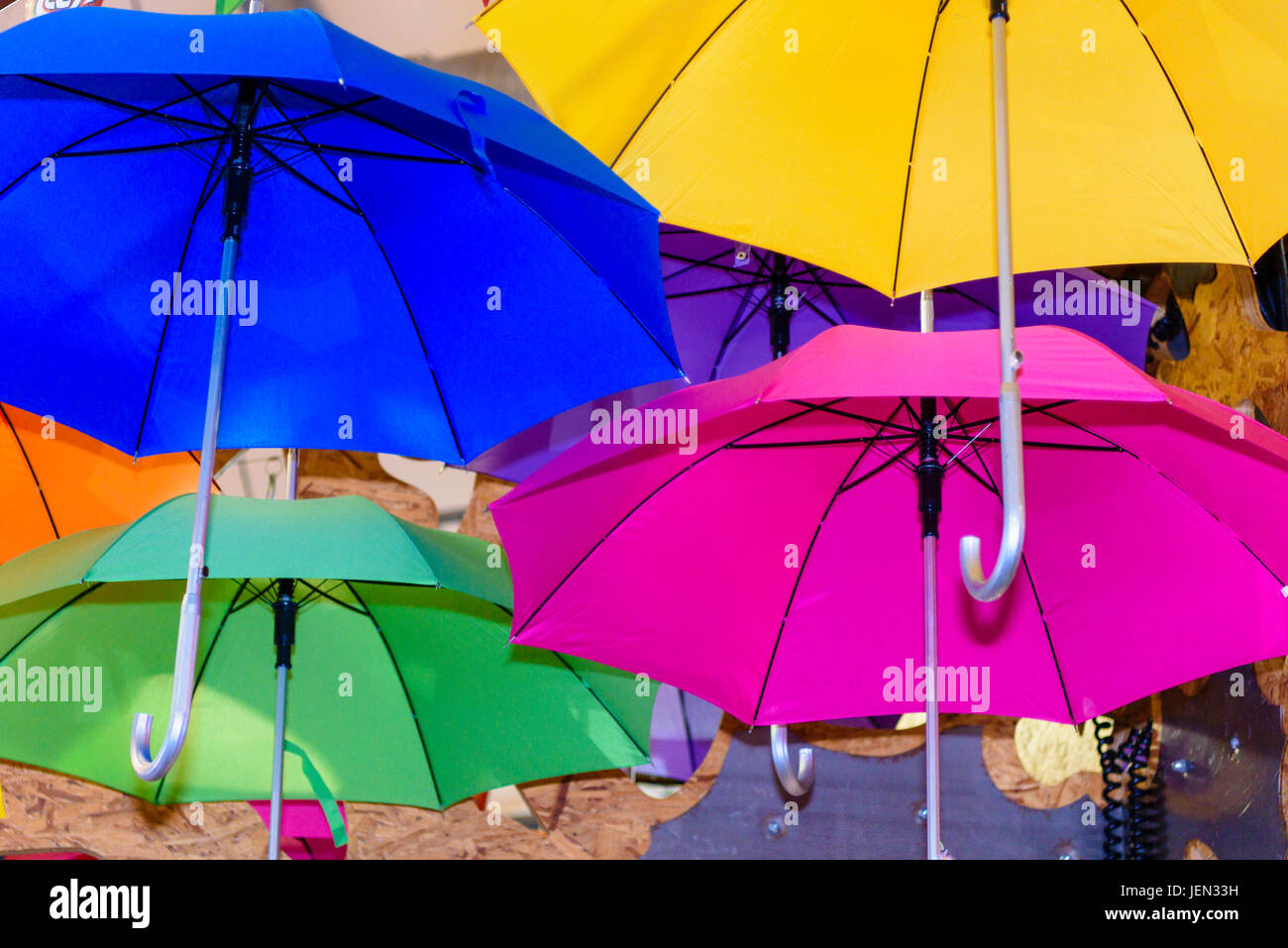 Colourful umbrellas hang from a ceiling Stock Photo