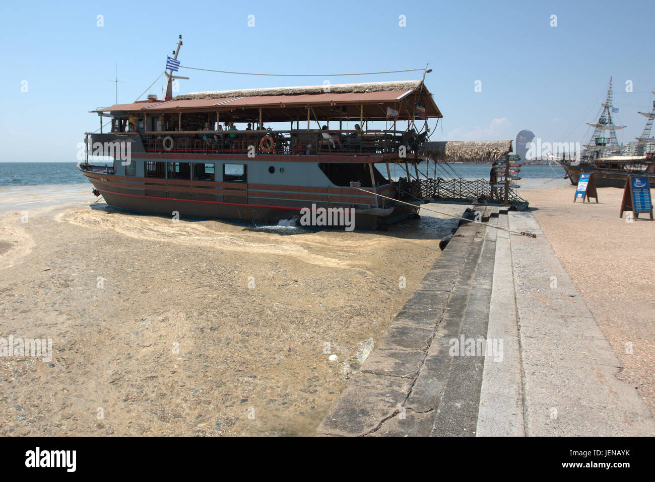 Thessaloniki, Greece. 27th June, 2017. A tourist boat waits for customers in a red tide affected seafront of the northern Greek port city of Thessaloniki. Red tide is a common name for a phenomenon known as an algal bloom, caused by species of dinoflagellates, taking on a red or brown colour. Credit Credit: Orhan Tsolak/Alamy Live News Stock Photo