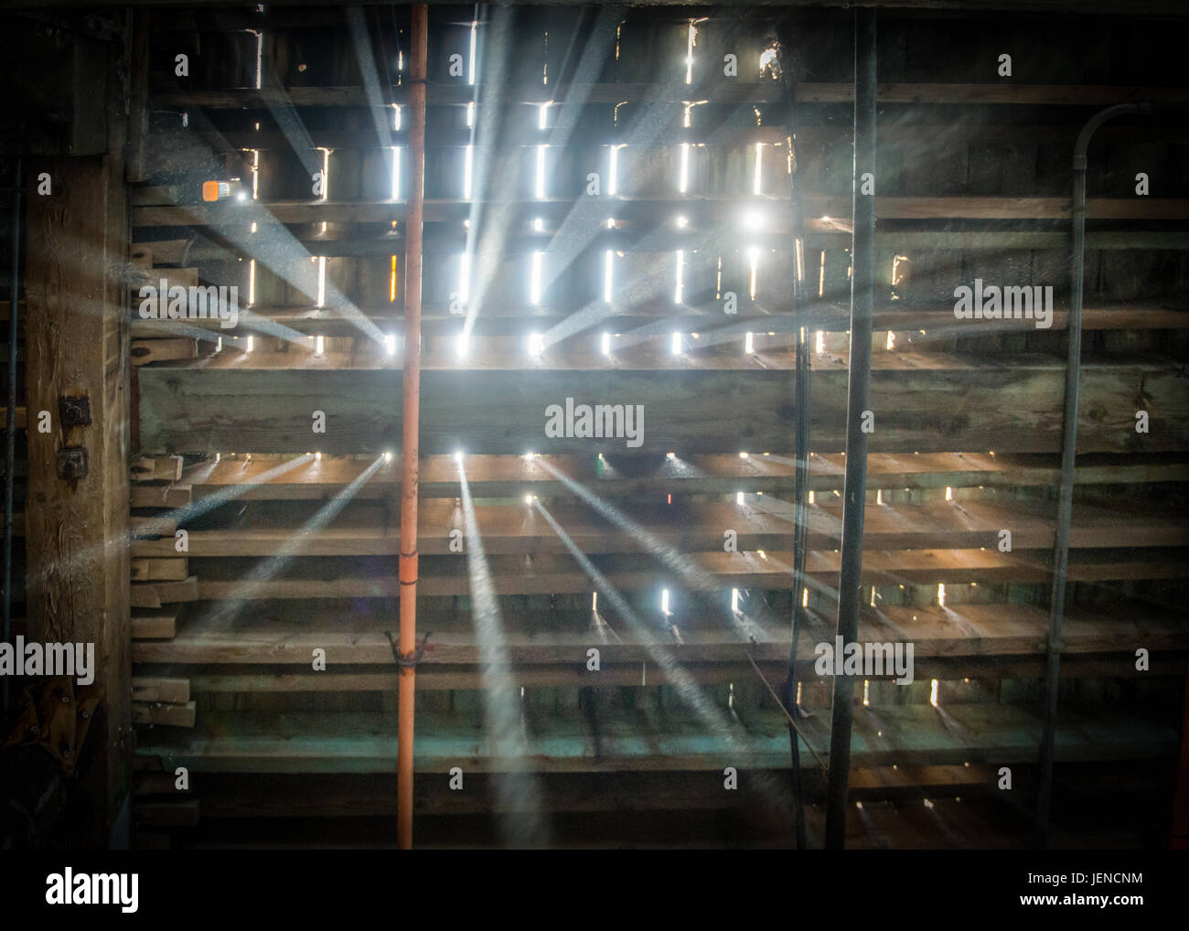 Sunlight shining through wooden rafters in the attic Stock Photo