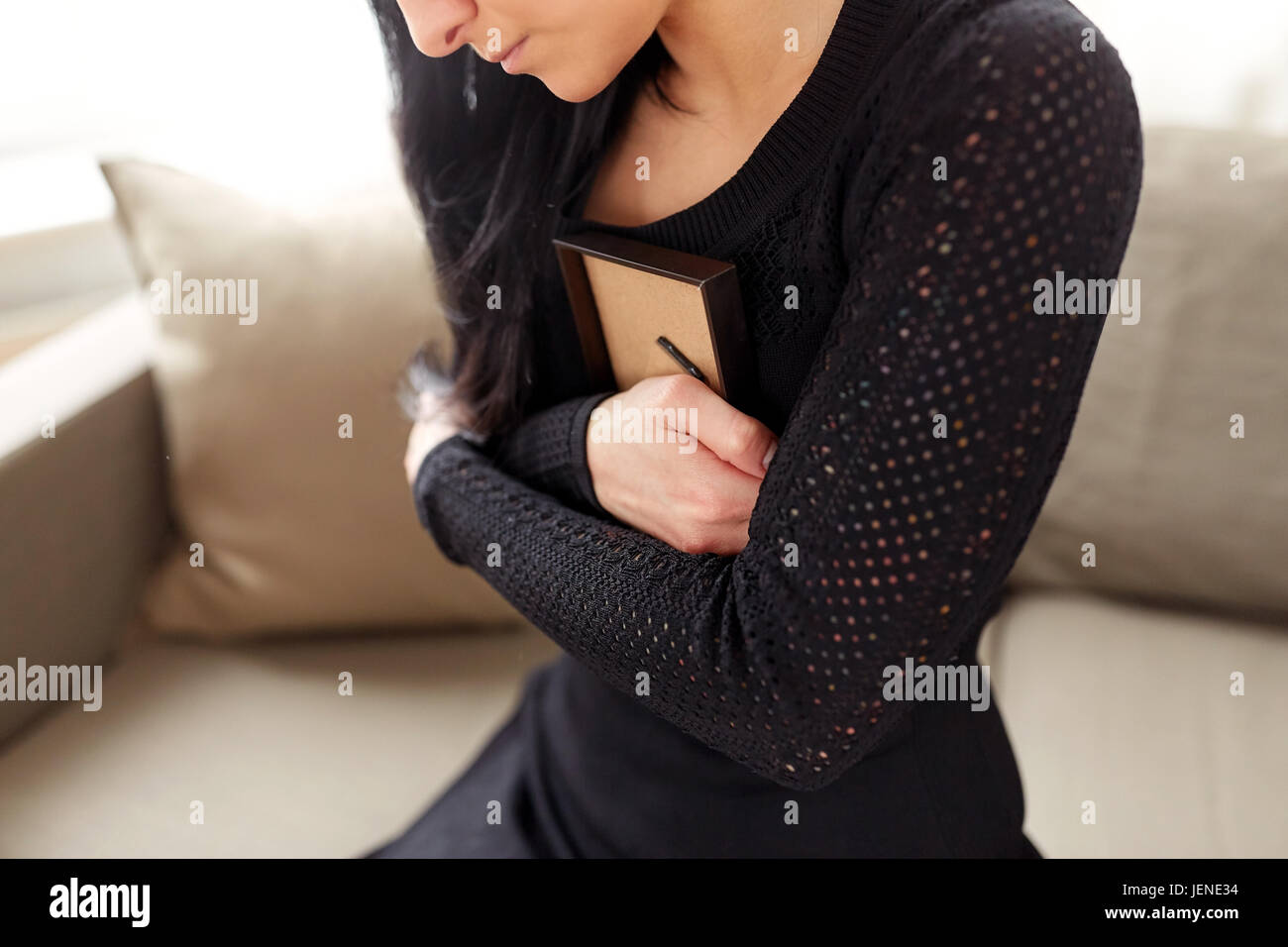woman with photo frame at funeral day Stock Photo