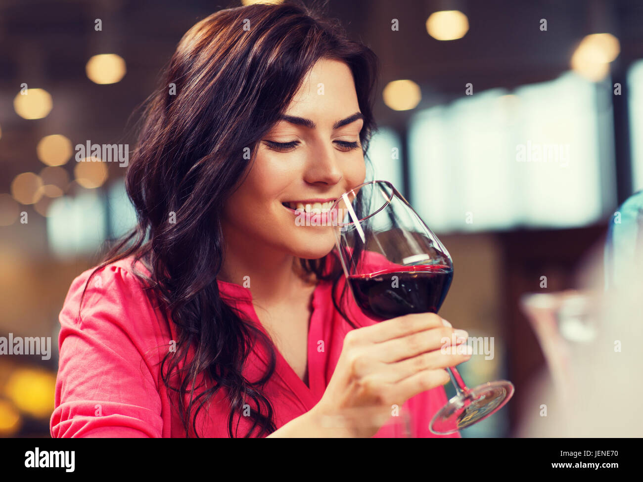 smiling woman drinking red wine at restaurant Stock Photo
