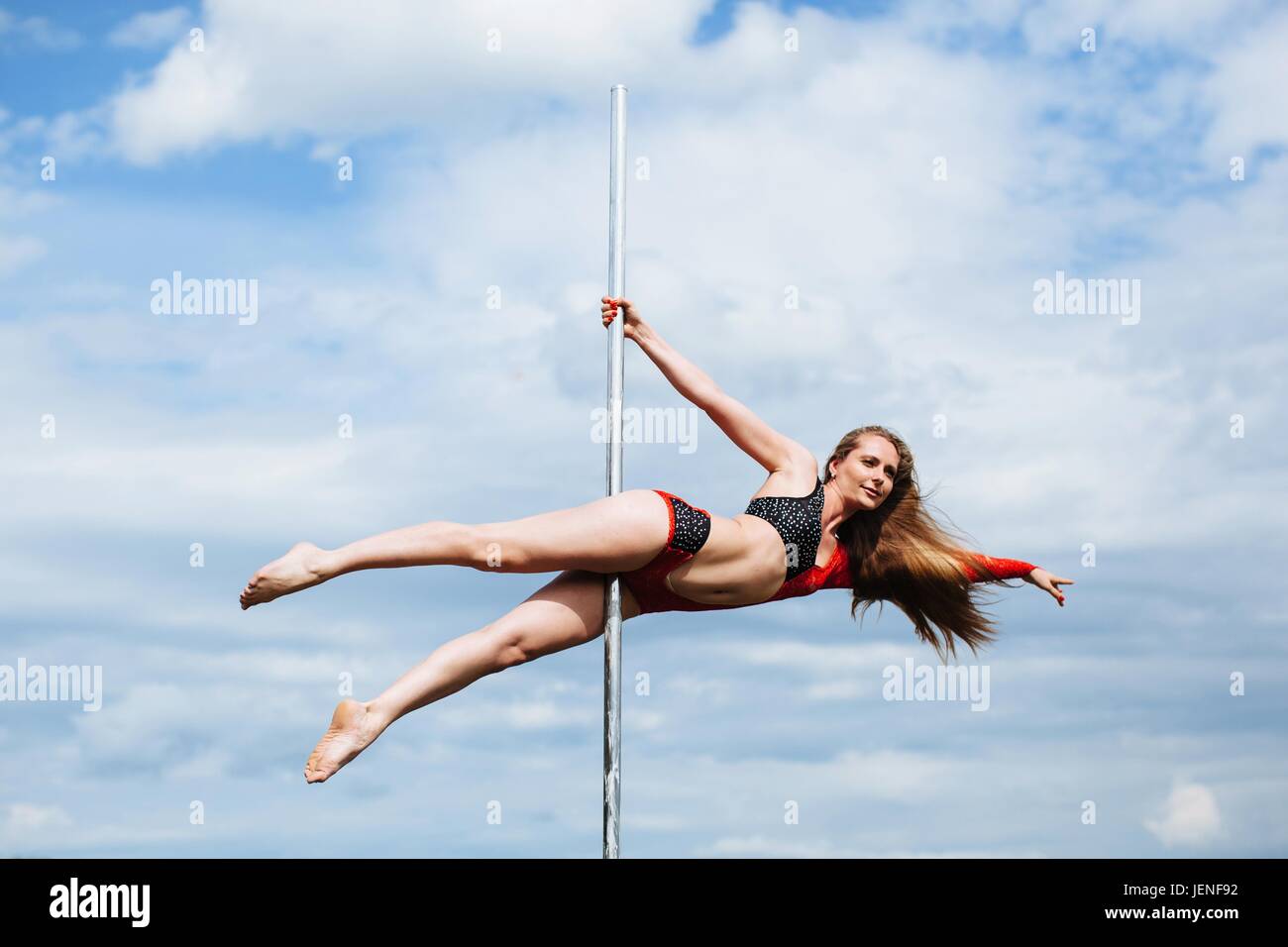 Woman pole dancing outdoors Stock Photo