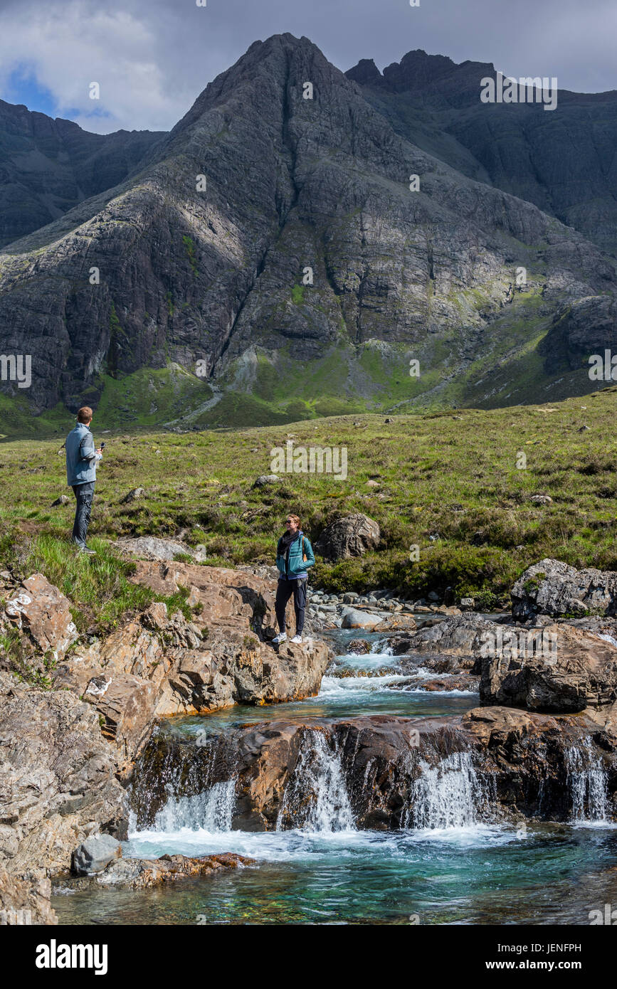Black Cuillin and tourists visiting the Fairy Pools, succession of waterfalls in Glen Brittle on the Isle of Skye, Scottish Highlands, Scotland, UK Stock Photo
