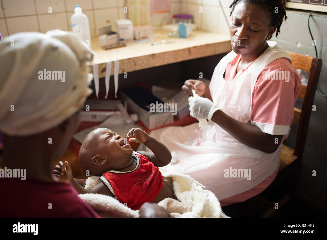 A nurse administers medication to a child intravenously at a hospital in Bundibugyo, Uganda. Stock Photo