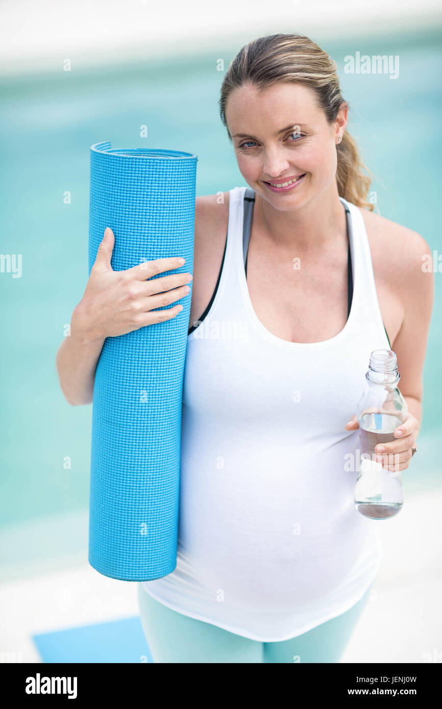 Pregnant woman holding water bottle and mat Stock Photo Alamy