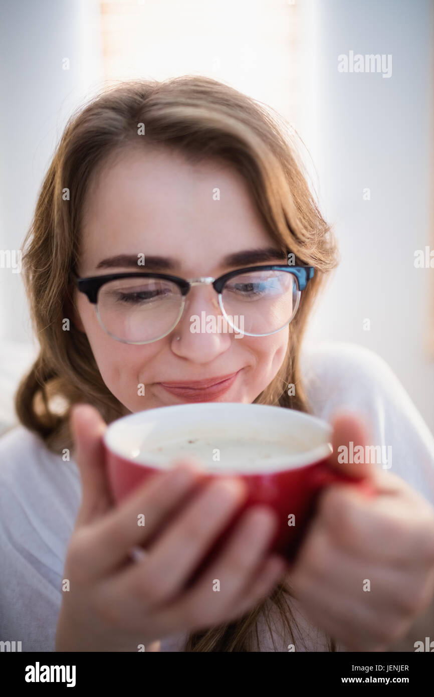 Pretty woman relaxing on couch with coffee Stock Photo - Alamy