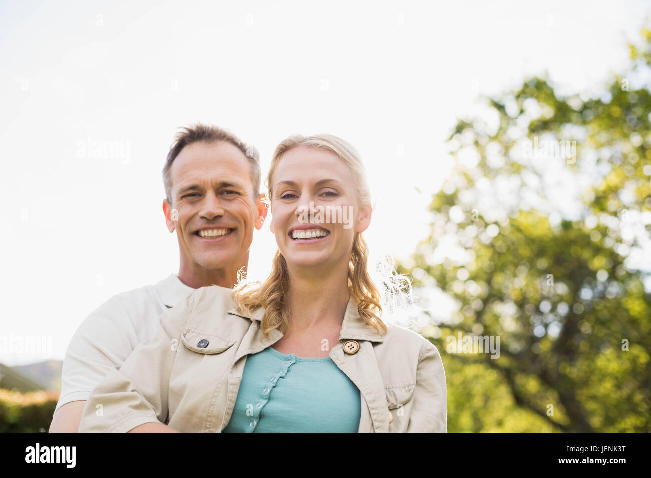 Cute couple with arms around each other Stock Photo - Alamy