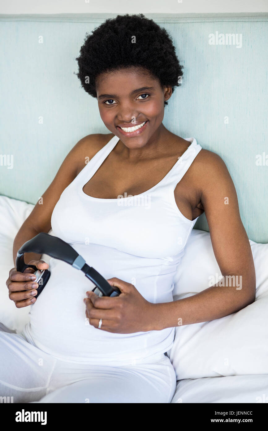 Music and pregnancy. Expectant woman holding headphones near belly Stock  Photo - Alamy