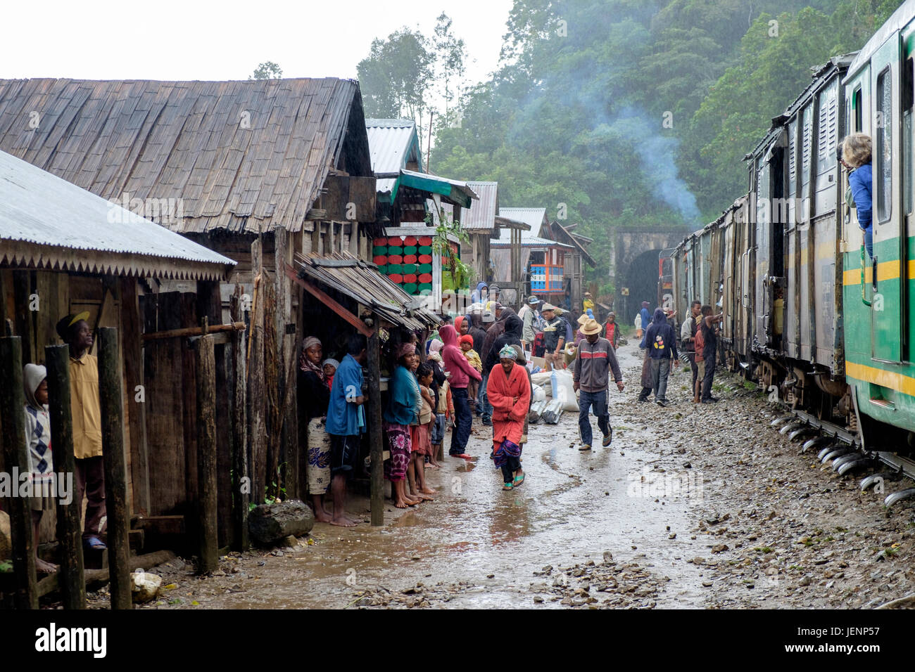 Travellers and local people wait at the side of the tracks during one of the 18 stops on the Fianarantsoa-Côte Est Railway which runs between Fianaran Stock Photo