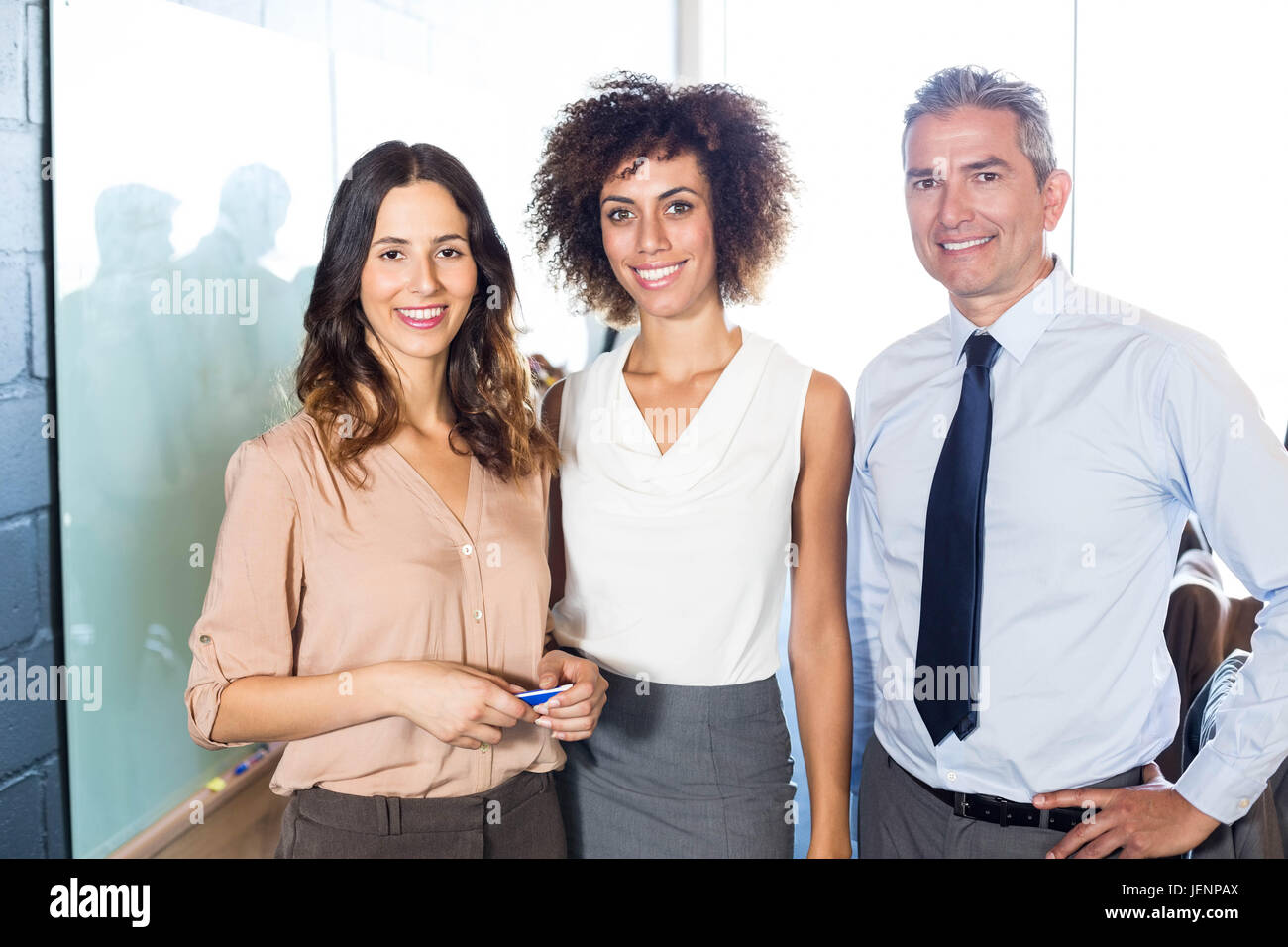 Businesspeople standing together in office Stock Photo - Alamy