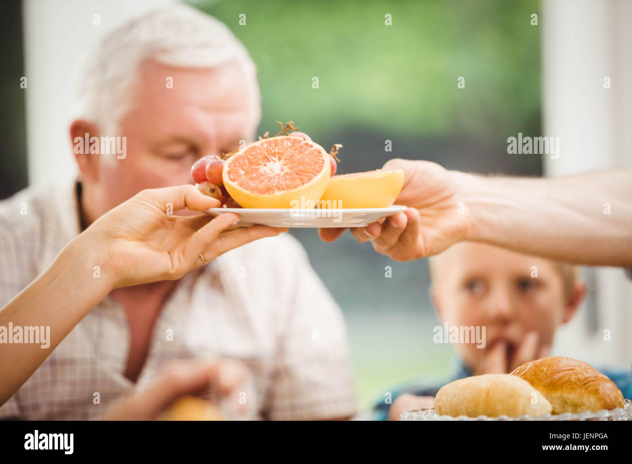 Closeup of hands passing plate of fruits Stock Photo Alamy