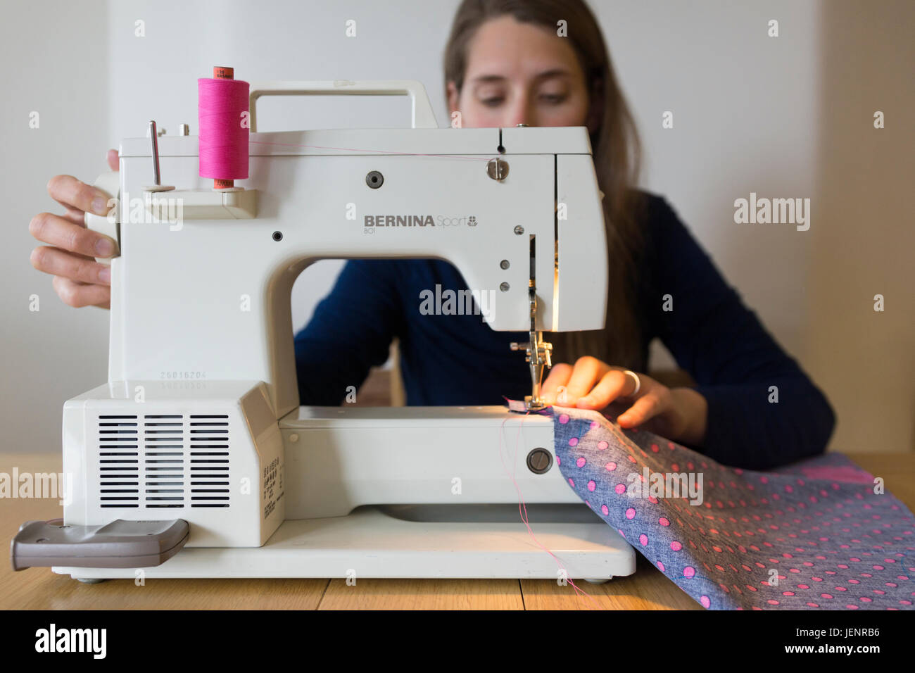 A young woman using a sewing machine. Theme hobbies, arts and crafts