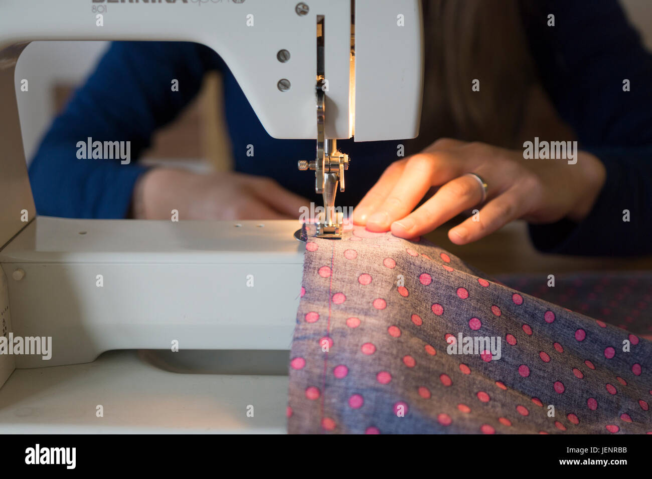 A young woman using a sewing machine. Theme hobbies, arts and crafts