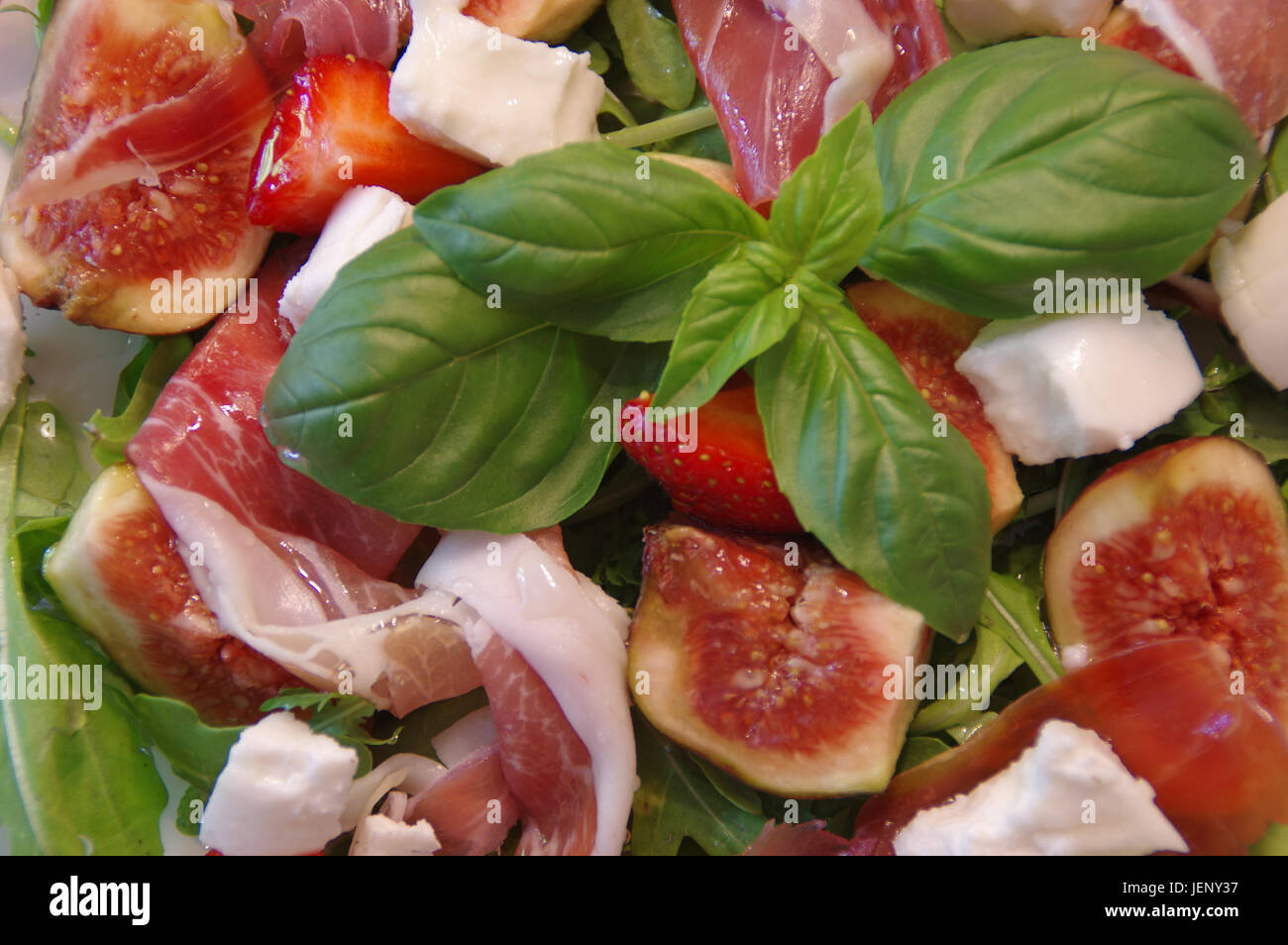 Mediterranean salad with fig, prosciutto ham, rucola and basil leaf Stock Photo