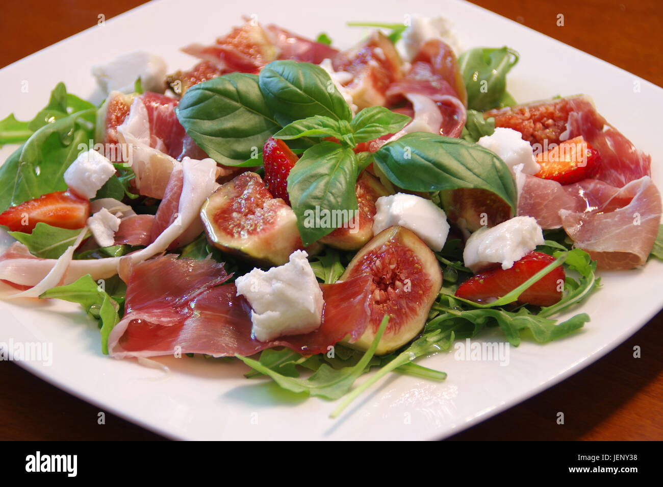 Mediterranean salad with fig, prosciutto ham, rucola and basil leaf Stock Photo