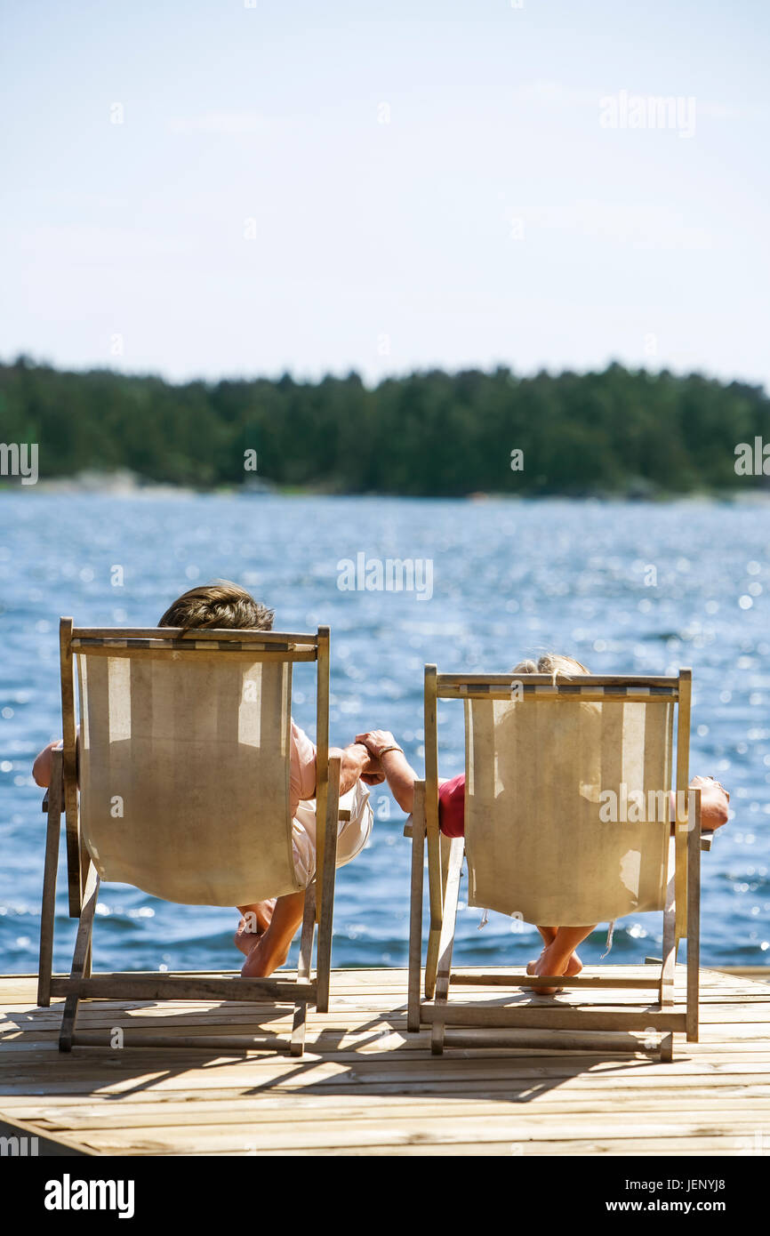 Couple on deckchairs at lake Stock Photo - Alamy