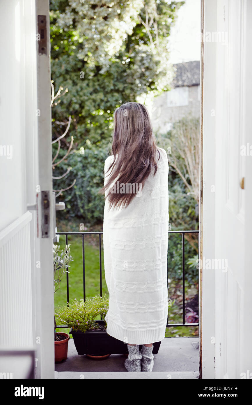 Woman wrapped in blanket standing on balcony Stock Photo - Alamy