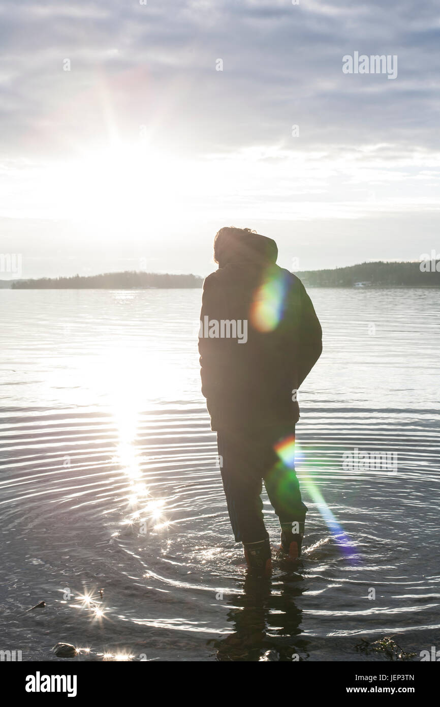 Silhouette of man standing in water Stock Photo - Alamy