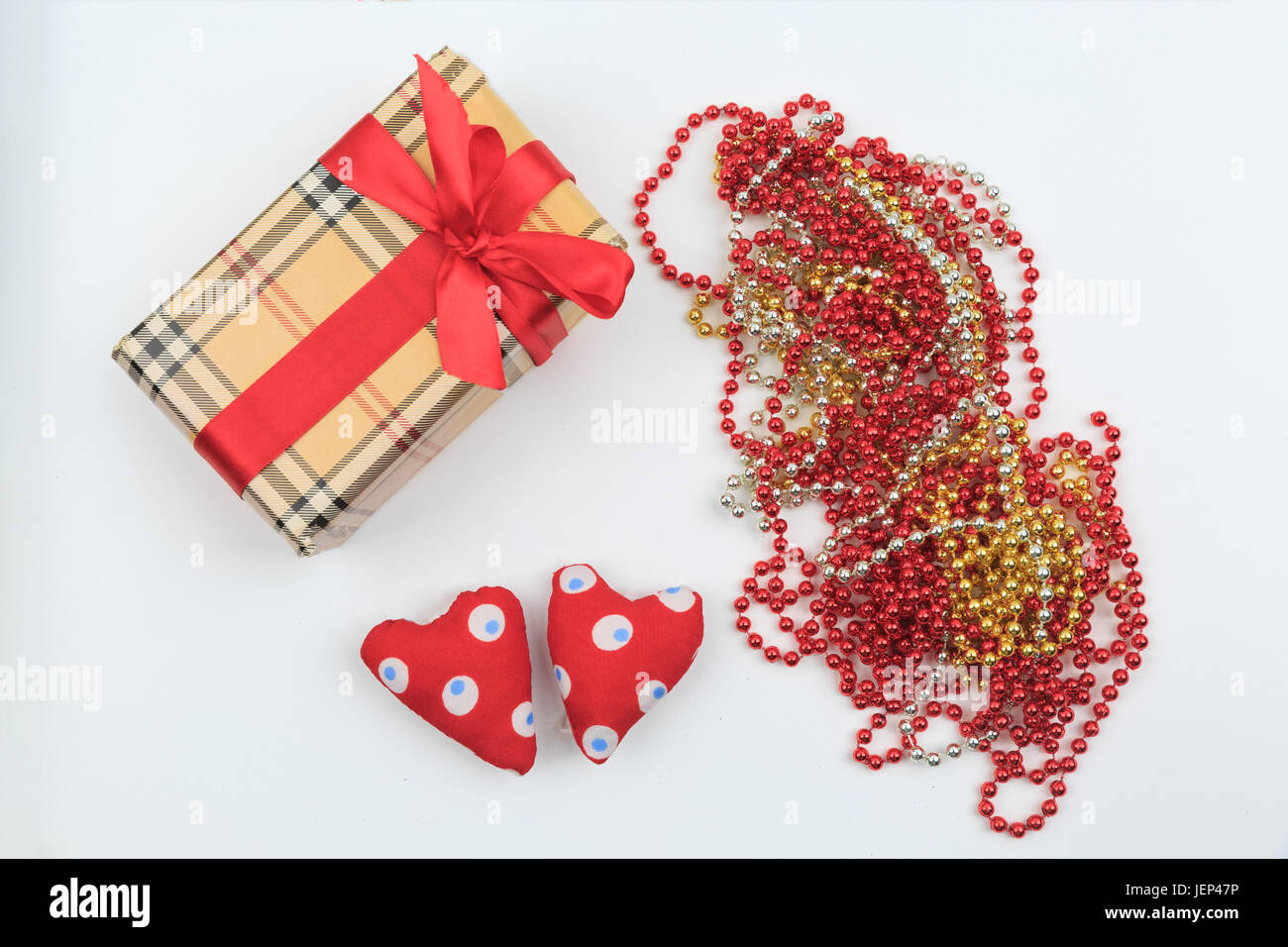Gift box, beads and heart shape on white backgroud. Top view. Flat lay Stock Photo