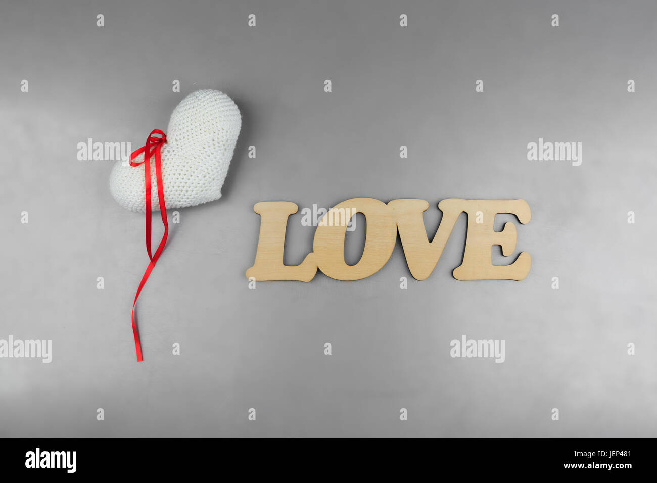 Word love with knitted heart on grey table. Top view. Flat lay Stock Photo