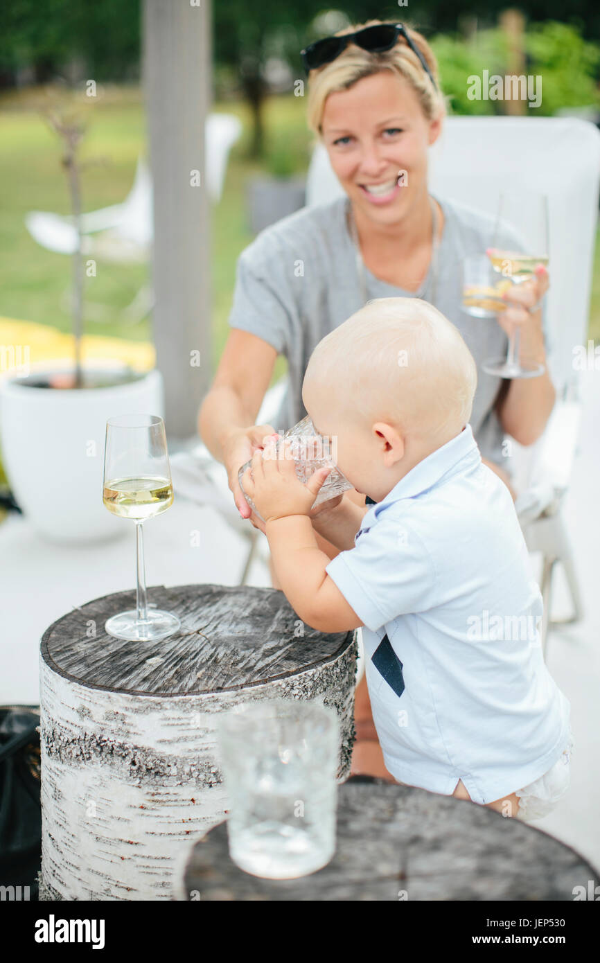 Baby boy drinking from glass Stock Photo