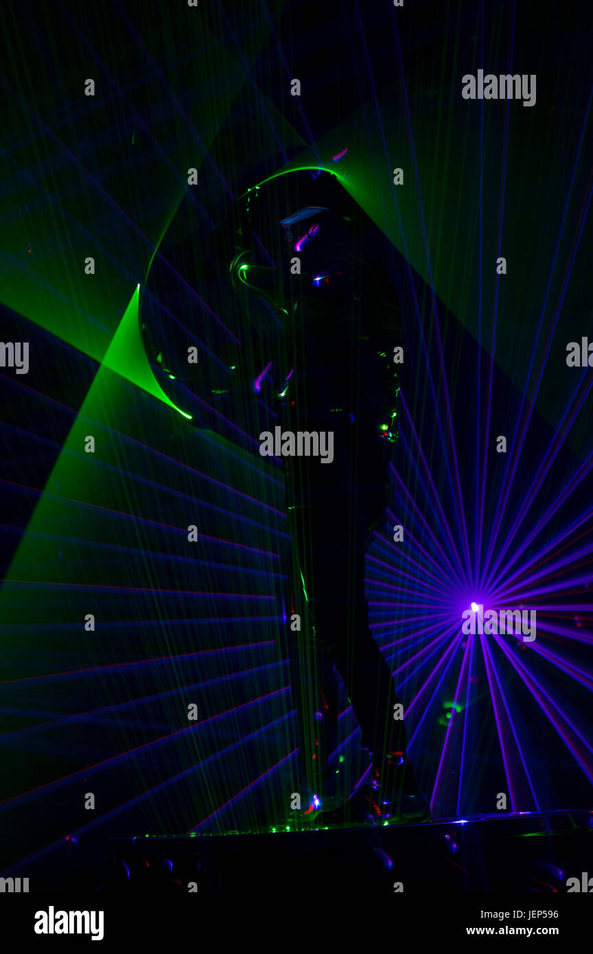 Disco dance with special light effects and fantastic laser show. Blue and green rays. Stock Photo