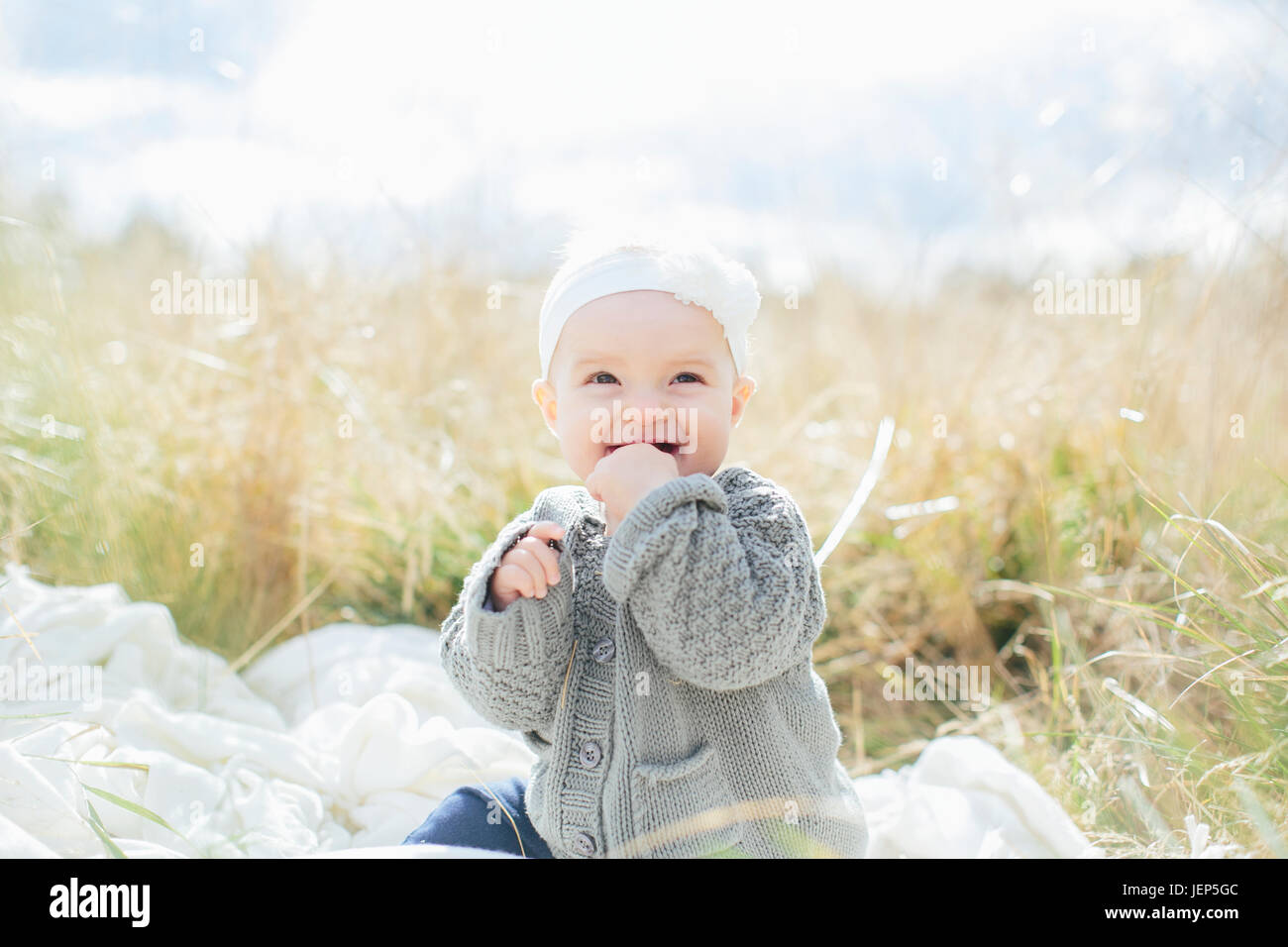 Happy girl sitting on meadow hi-res stock photography and images - Alamy