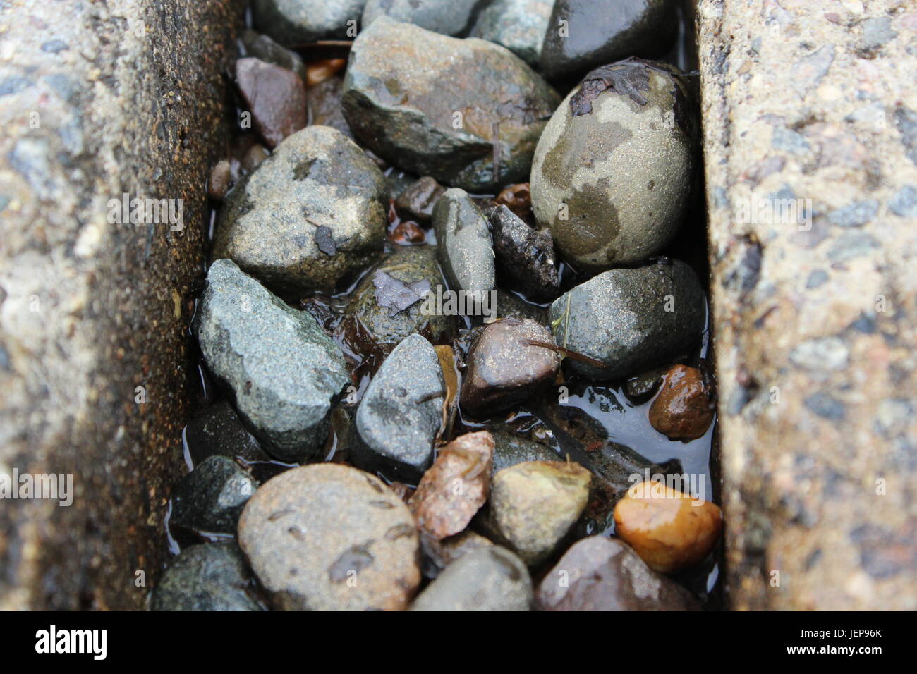 Variety of rocks stuck inside a large crack. Stock Photo