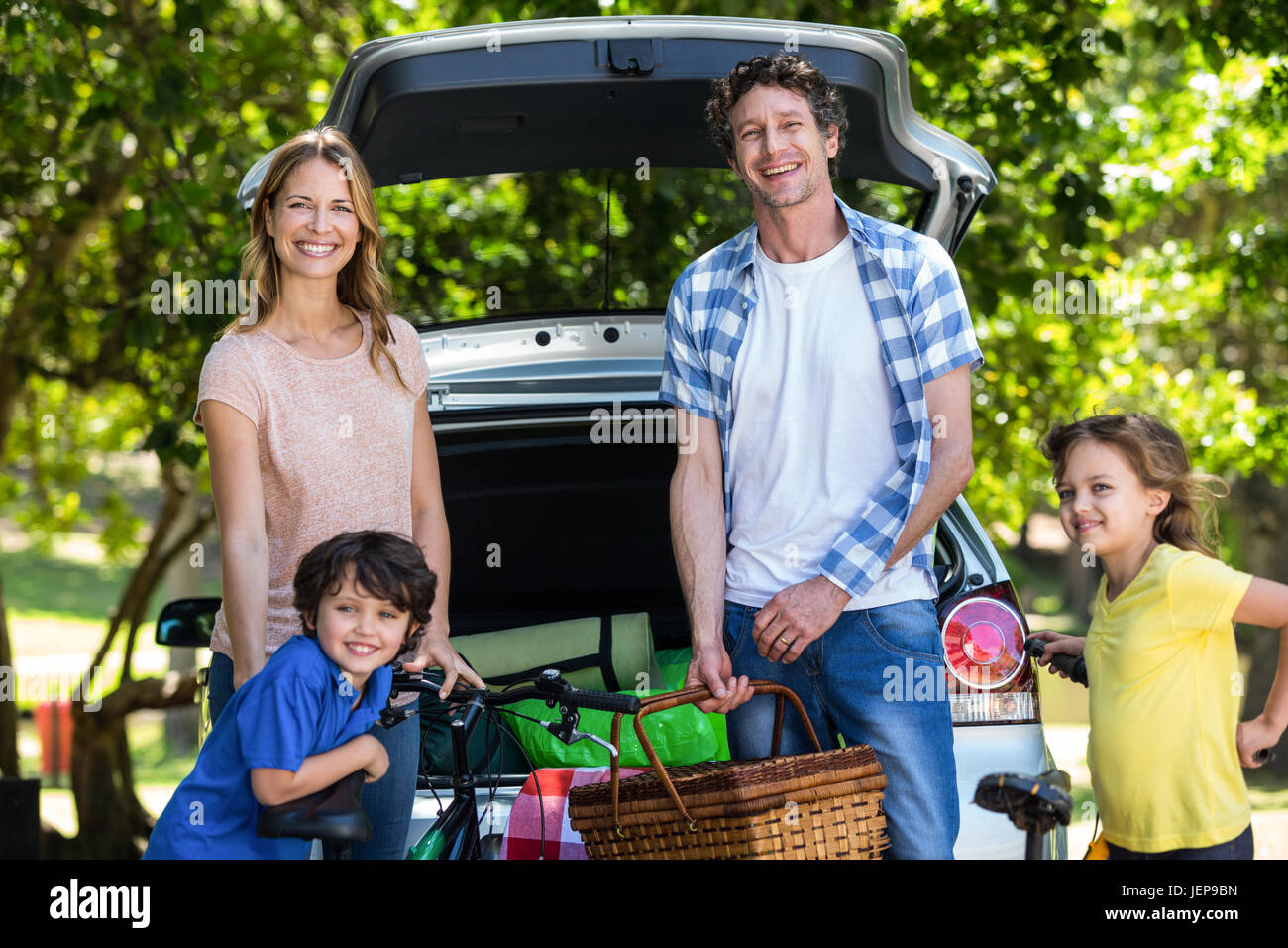 Smiling family in front of a car Stock Photo