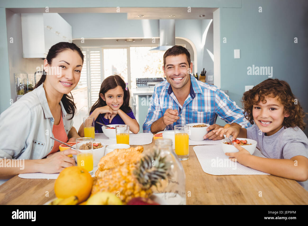 Portrait of happy family having breakfast Stock Photo - Alamy