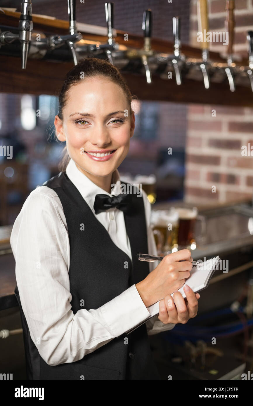 Barmaid taking orders on notepad Stock Photo Alamy