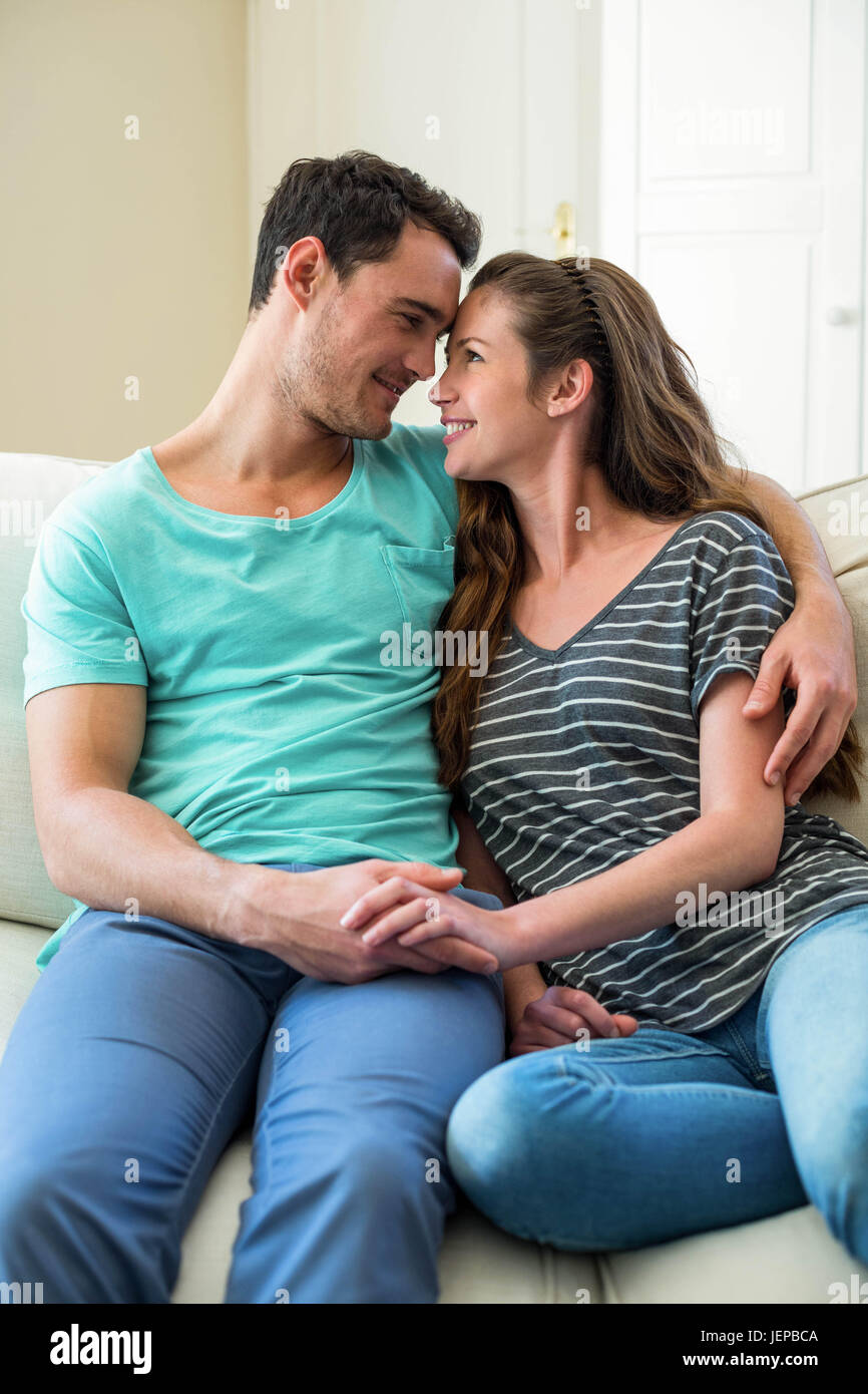 Young couple cuddling on sofa Stock Photo Alamy
