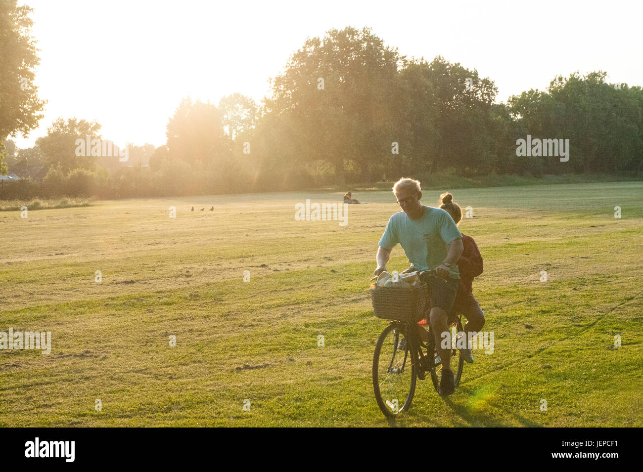 A happy scene in the sunshine as a boy and a girl share a bike ride