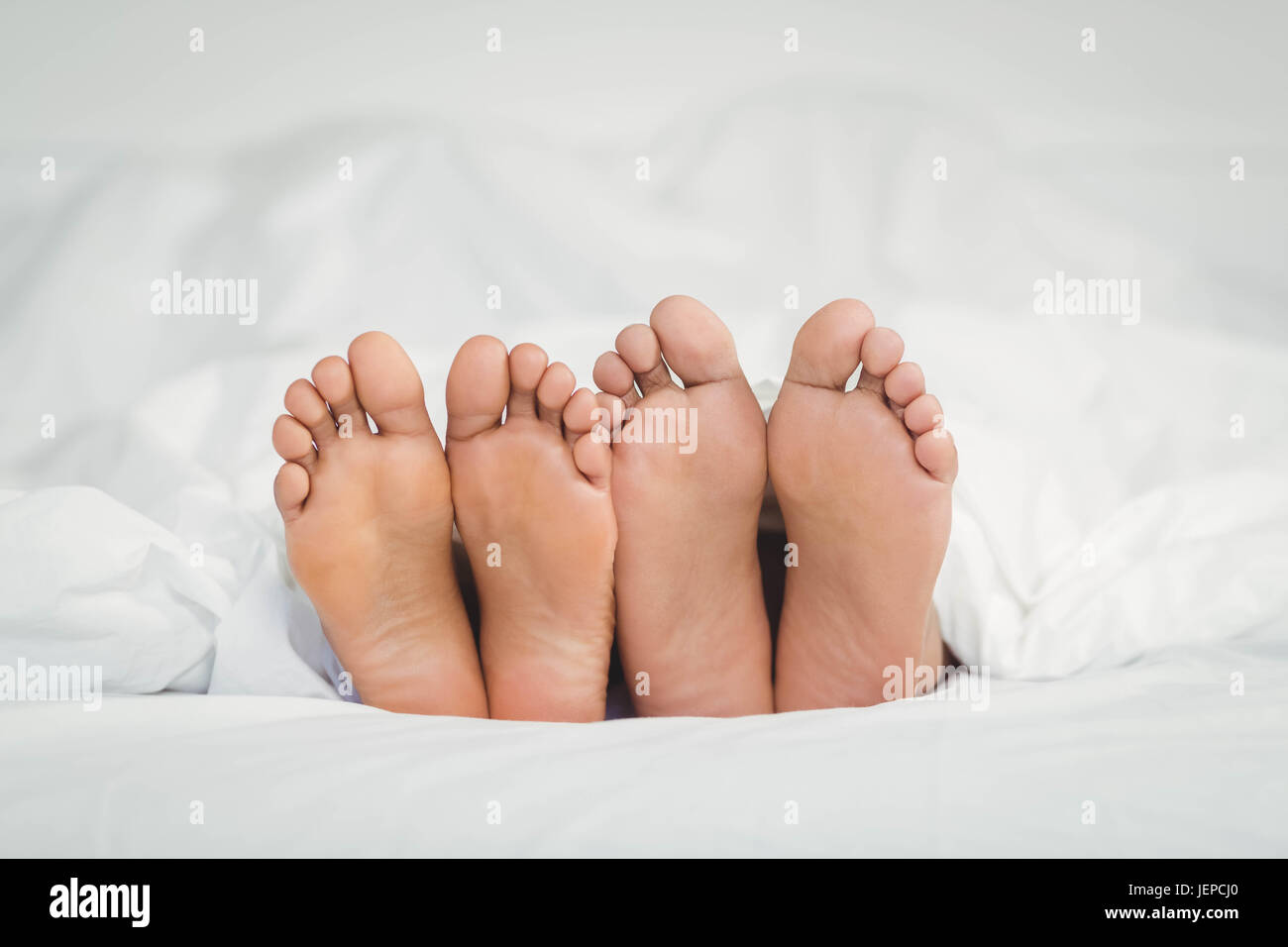 Feet sticking out from the blanket Stock Photo Alamy