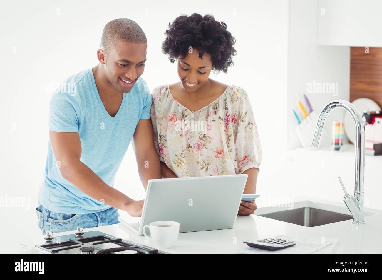 Smiling couple using laptop together Stock Photo - Alamy