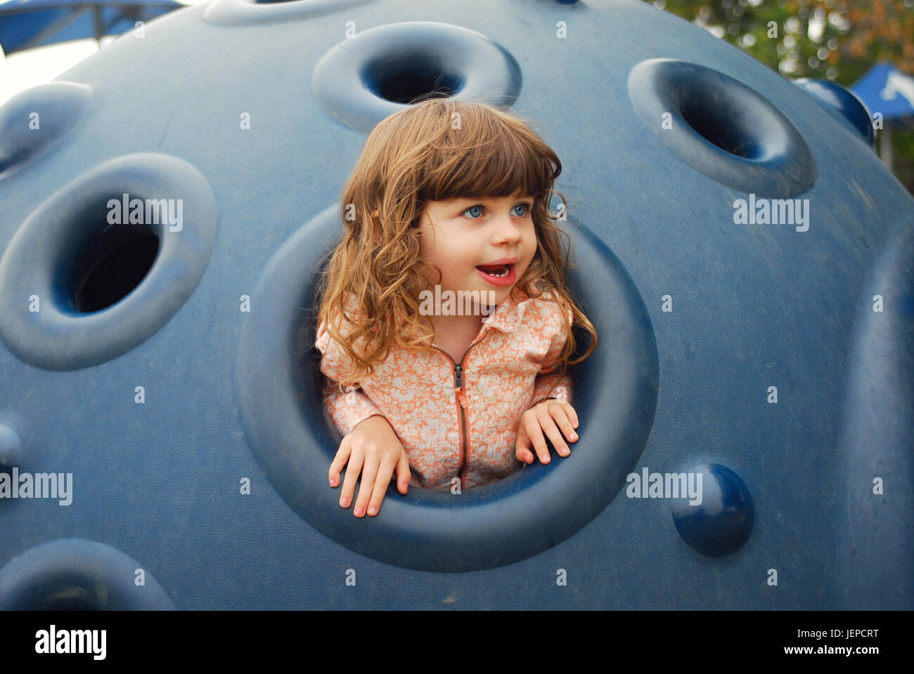 Little girl playing on toys at park Stock Photo - Alamy