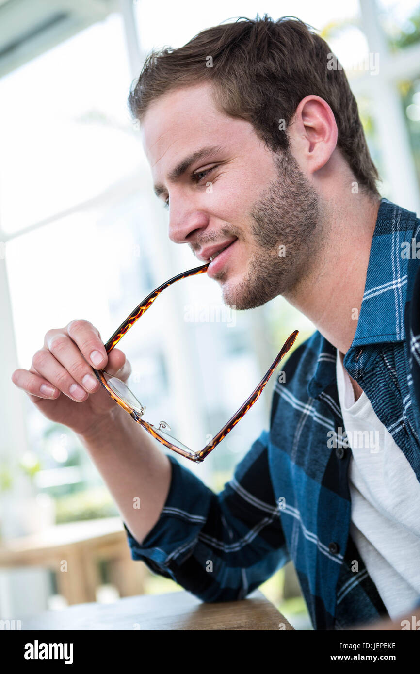 Handsome man working and chewing his glasses Stock Photo Alamy
