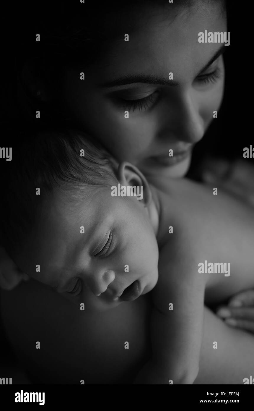 Model released photograph of a newborn baby boy resting on his mothers shoulders Stock Photo
