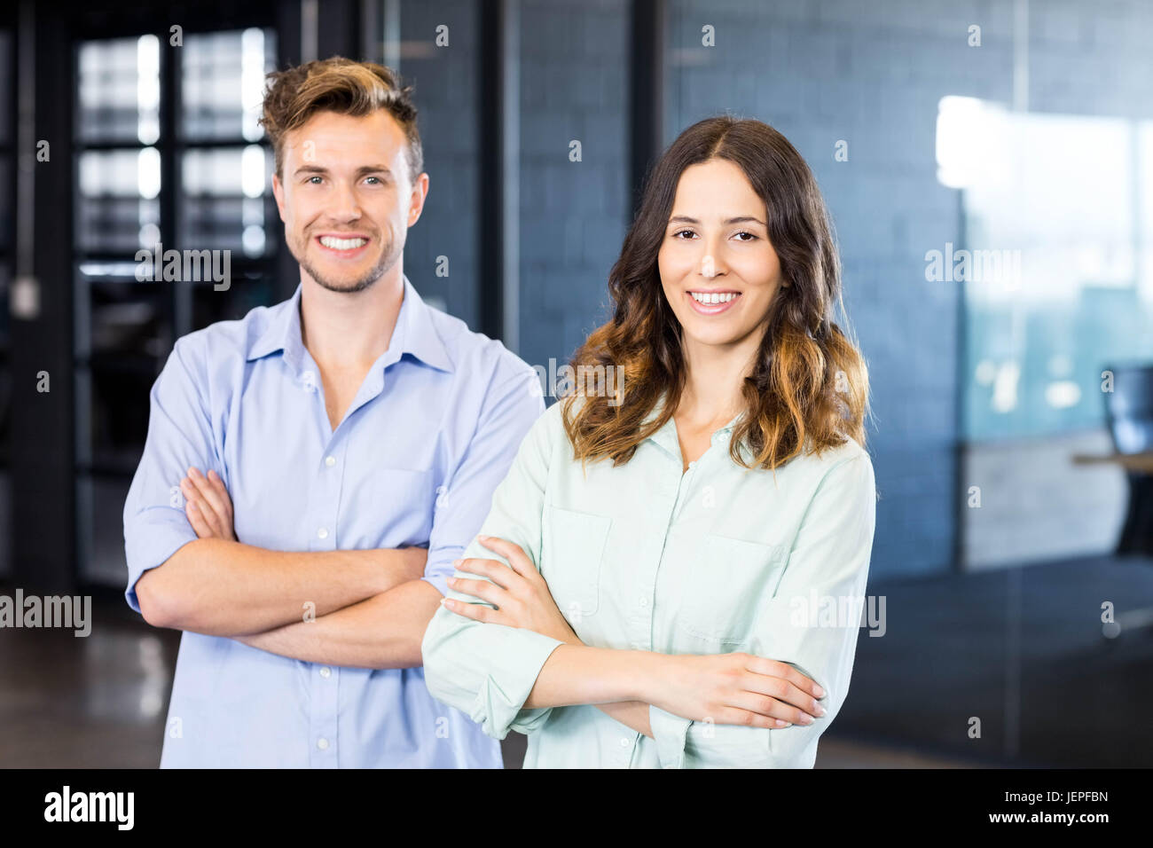 Portrait of colleagues standing in office Stock Photo - Alamy